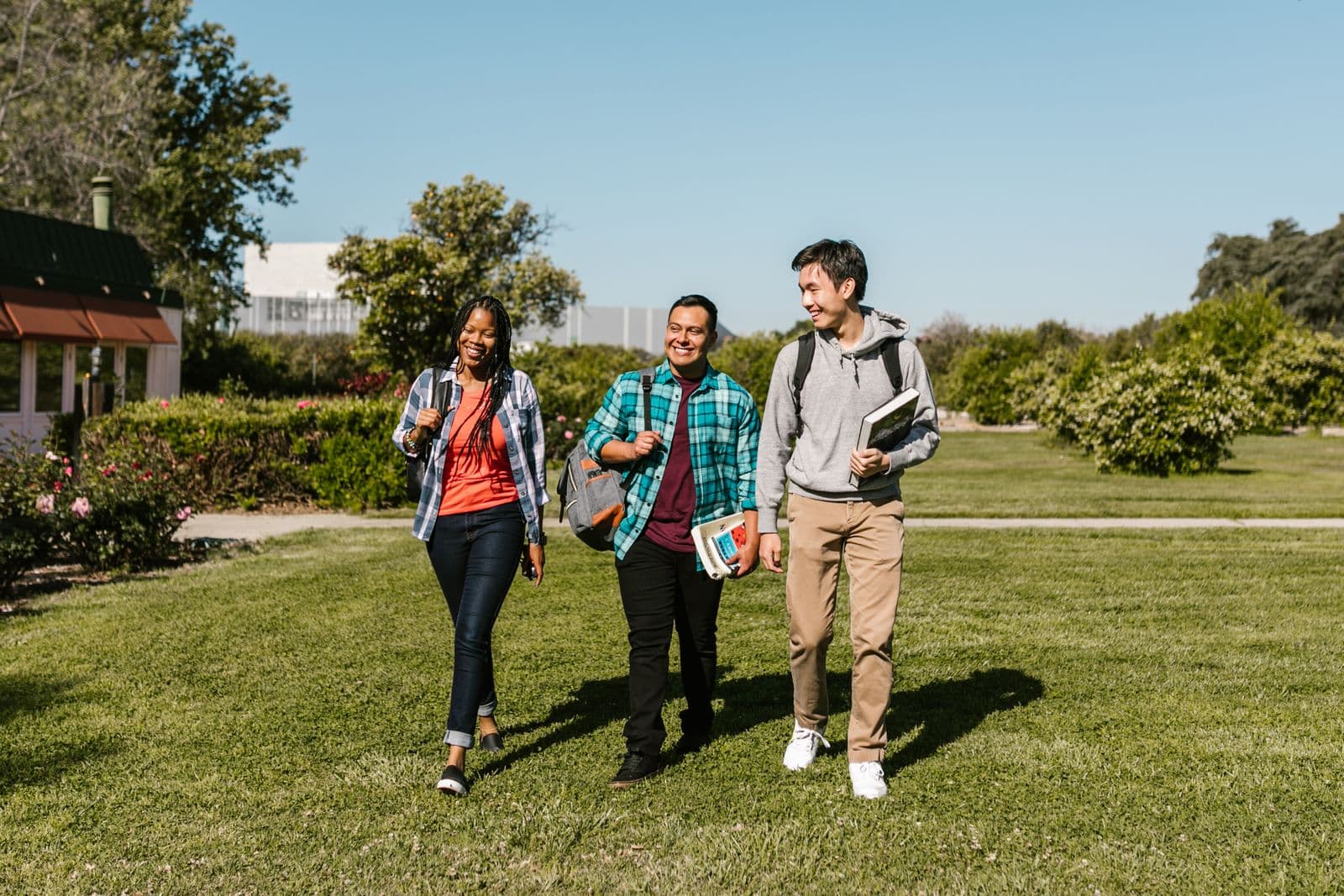 Three students walking together across a university campus